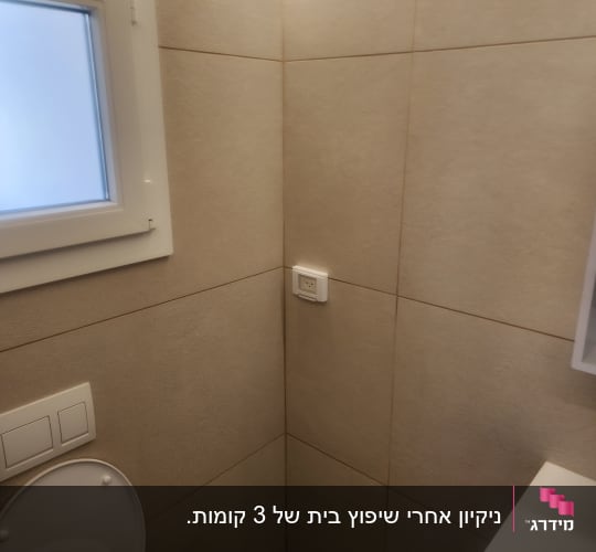 חדר שירותים עם אסלה וקיר מרוצף